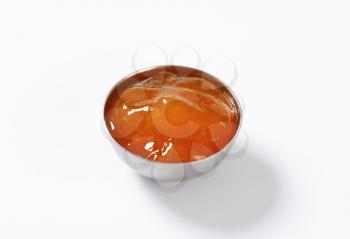 bowl of apricot jam on white background