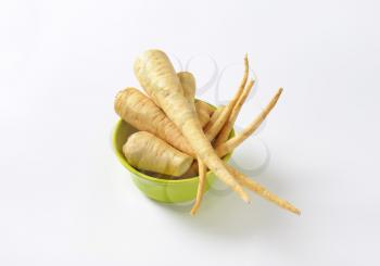 bowl of parsley roots on white background