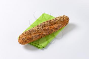 fresh baguette bread with seeds on green place mat