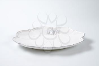 white embossed ceramic plate with decorative edge