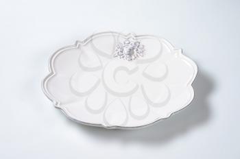white embossed ceramic plate with decorative edge