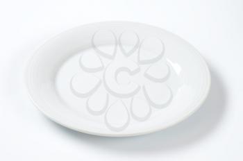 empty white dinner plate with ribbed rim