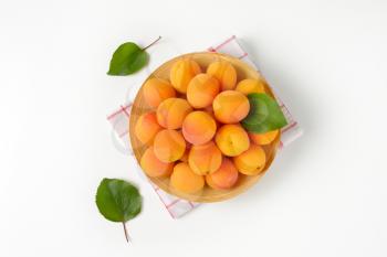 Heap of fresh ripe apricots on bamboo plate