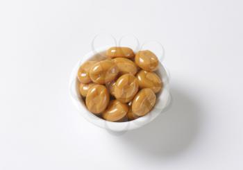 bowl of caramel candies on white background