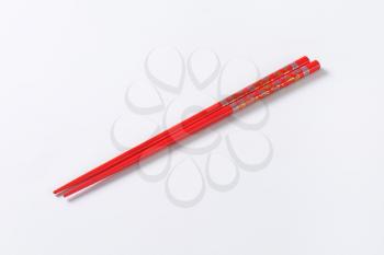 A pair of red chopsticks with floral pattern