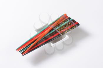 Set of colorful chopsticks with flower patterns on small white bowl