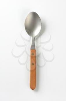 Empty metal table spoon with wooden handle