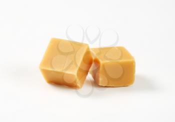 Two caramel candies on white background