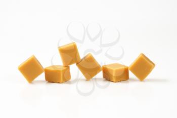 Chewy toffee candies on white background