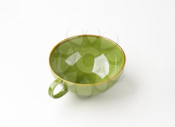 empty green soup bowl with one handle on white background