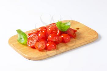 Halved cherry tomatoes on cutting board