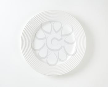 White porcelain plate with embossed rings on the rim