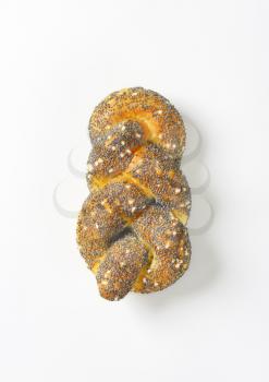 Braided bread roll topped with poppy seeds and salt