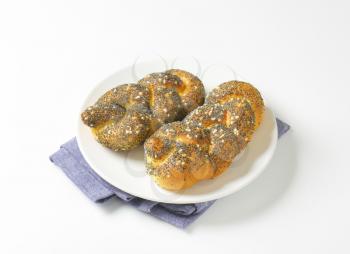 Braided bread rolls topped with poppy seeds and salt