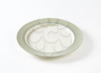 Charger plate with wide grey rim decorated with a pattern of subtle rings