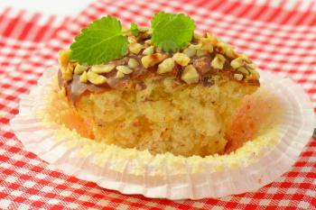 Muffin topped with chocolate and chopped nuts