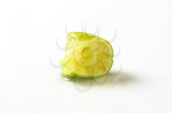 squeezed slice of lime on white background