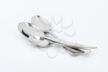 empty spoons on off-white background
