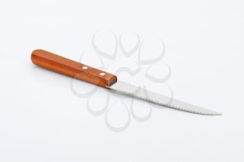 kitchen knife with serrated blade and wooden handle