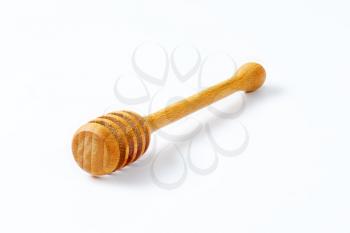 wooden honey dipper on white background