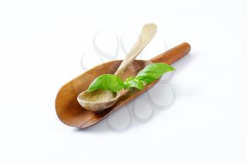 wooden scoop and spoon on off-white background with shadows