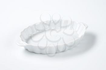 empty oval fluted white casserole dish