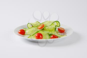 thin slices of fresh cucumber with halved cherry tomatoes