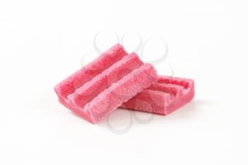 two pieces of pink chewing gum on white background