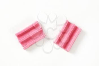 two pieces of pink chewing gum on white background