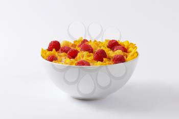 healthy breakfast - bowl of cornflakes and raspberries in milk