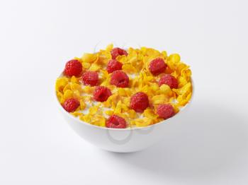 healthy breakfast - bowl of cornflakes and raspberries in milk