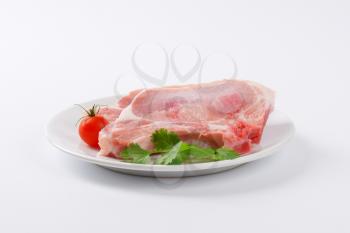 raw pork chops on white plate