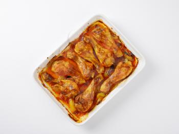 roasted chicken legs in white ceramic baking dish