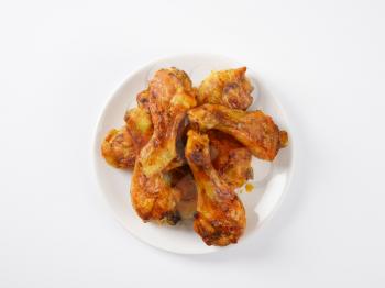 freshly roasted chicken legs on white plate