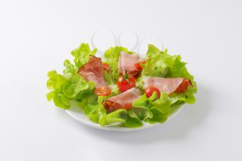 plate of fresh lettuce and dry cured pork ham (prosciutto)