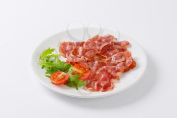 Cooked rashers of streaky bacon on plate