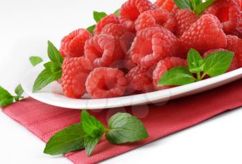 plate of fresh raspberries on red paper napkin