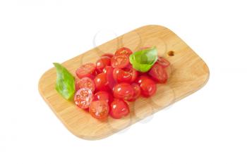 Halved cherry tomatoes on cutting board