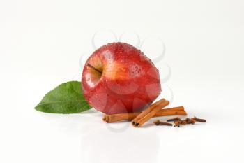 washed red apple and spice on white background