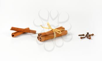 cinnamon sticks and dried cloves on white background