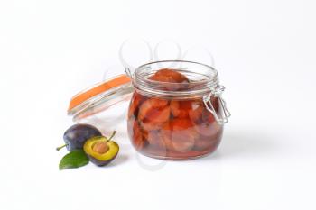 Plum compote in an open glass jar
