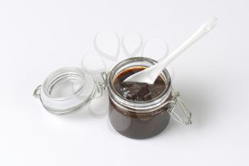 spoon in a jar of plum jam