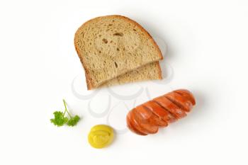 roasted sausage, mustard and bread slices on white background