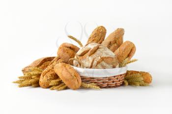 Various types of bread in a basket and next to it