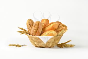 basket of various bread rolls and buns on white background
