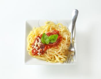 Spaghetti with meat-based tomato sauce and grated cheese