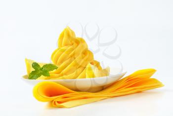 Swirl of yellow cream garnished with lemon wedges
