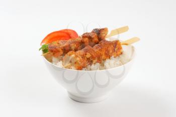 bowl of rice and grilled chicken skewers