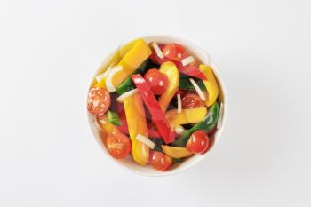 Bowl of fresh bell pepper strips and halved cherry tomatoes
