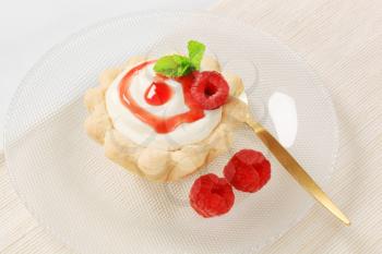 Mini tart with rich white cream and fresh red raspberries